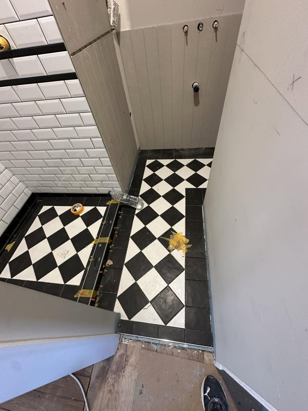 Black and white checkerboard floor tiling in progress