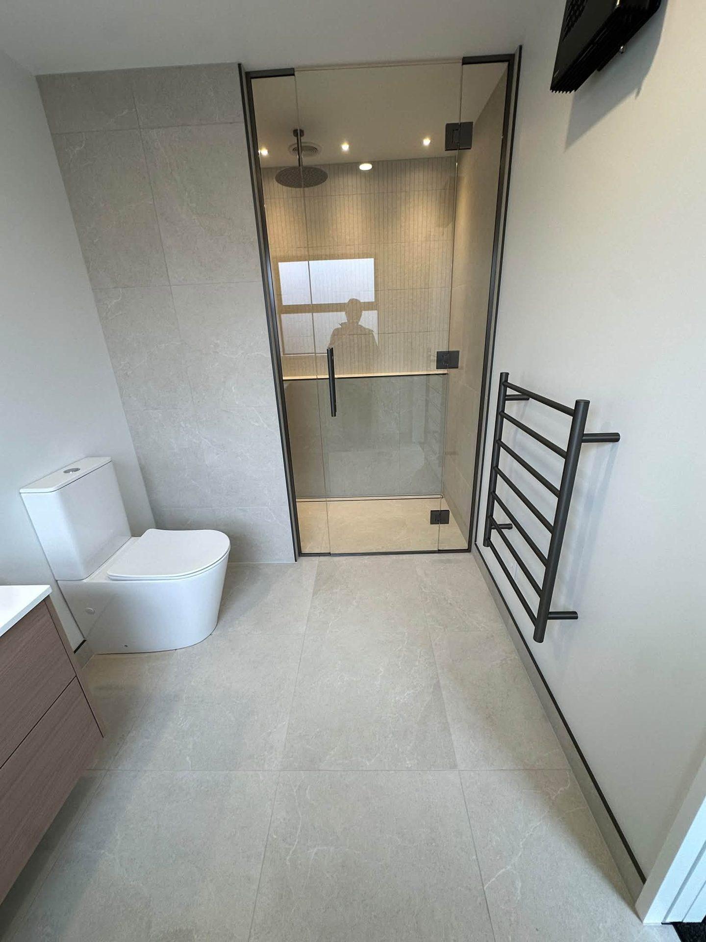 Ensuite shower tiled floor to ceiling with matte black fittings