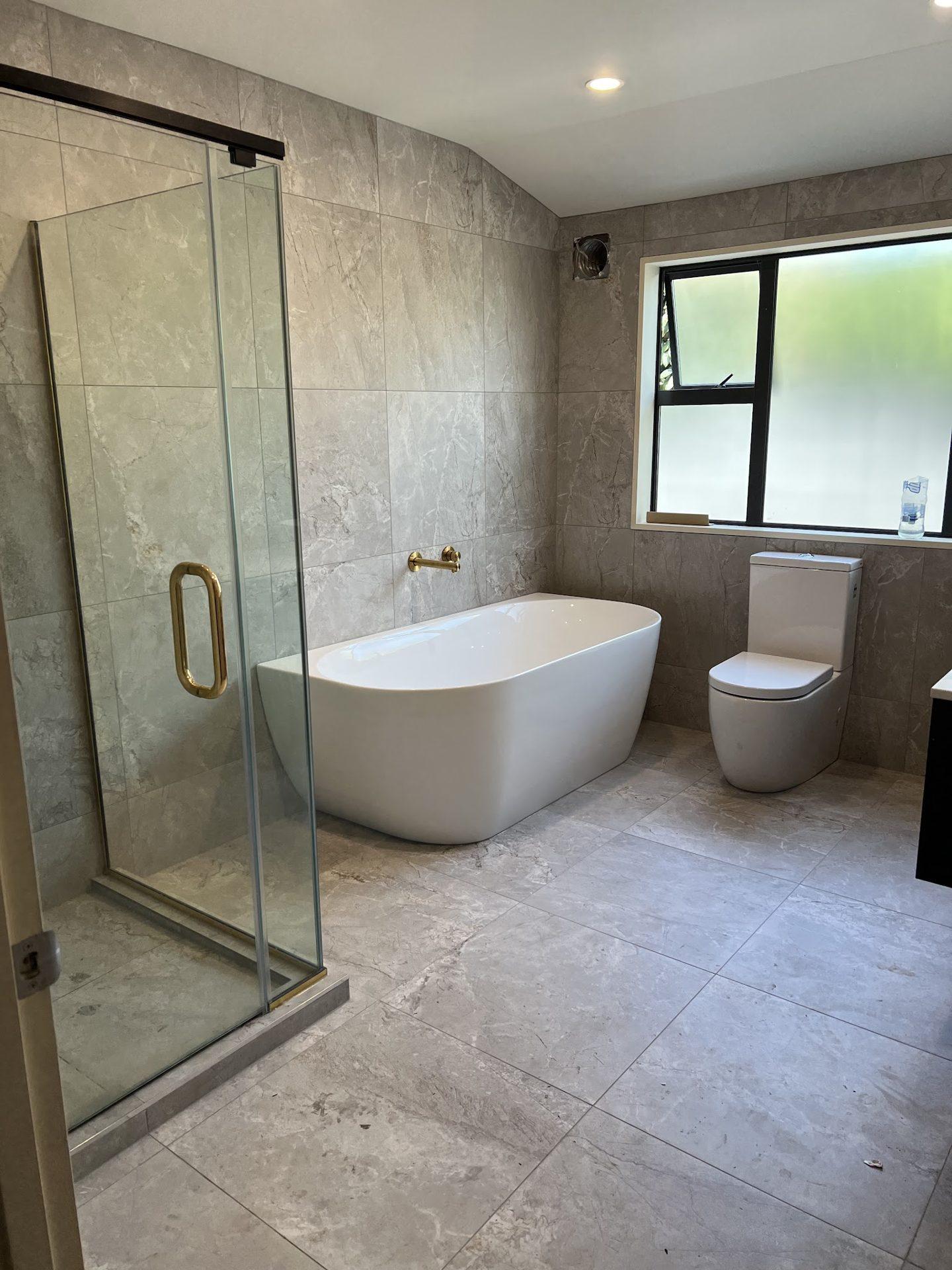 Family bathroom with freestanding bath and grey tiles