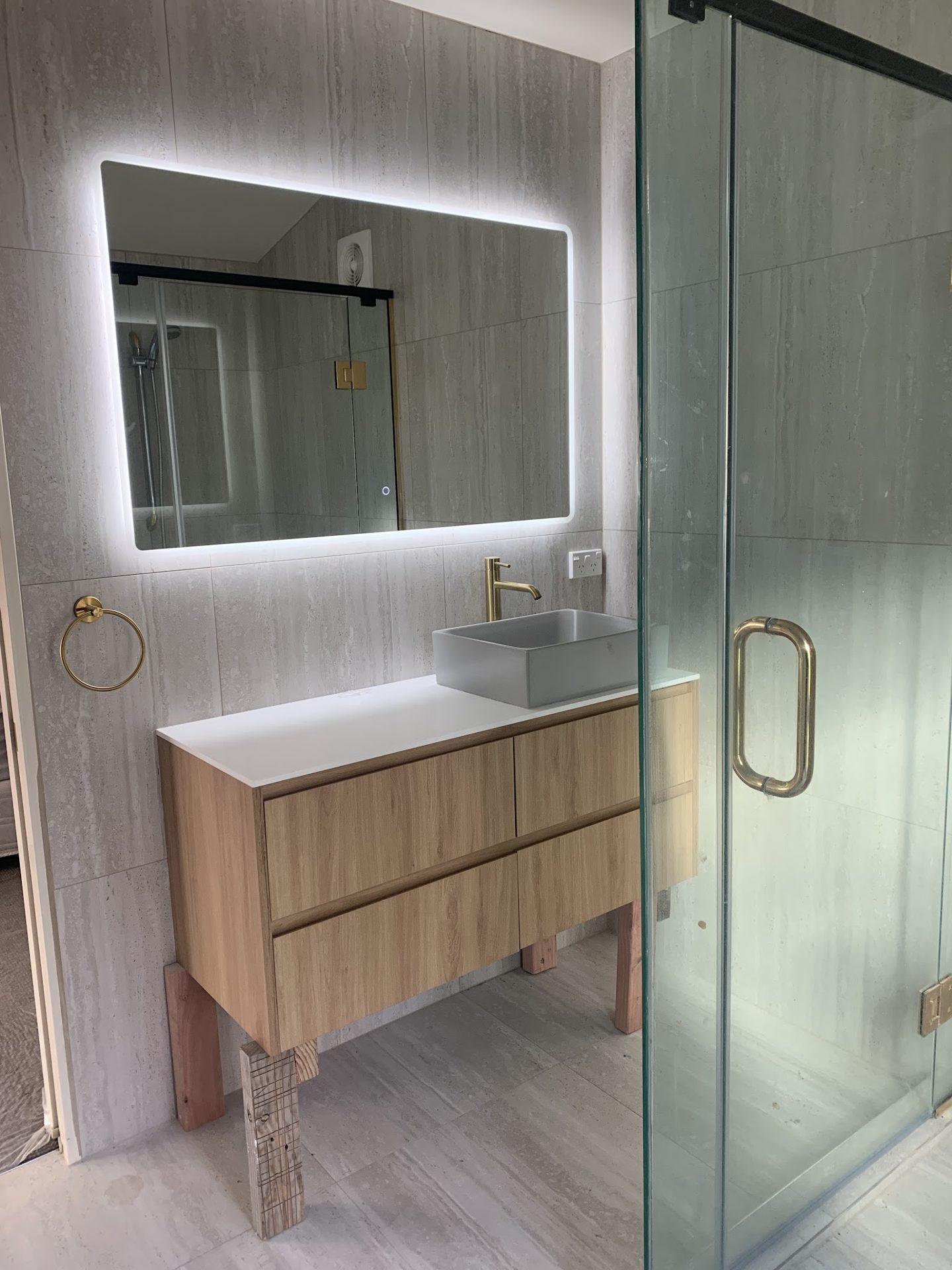 Family bathroom with tiled walls, vanity and brushed brass fittings