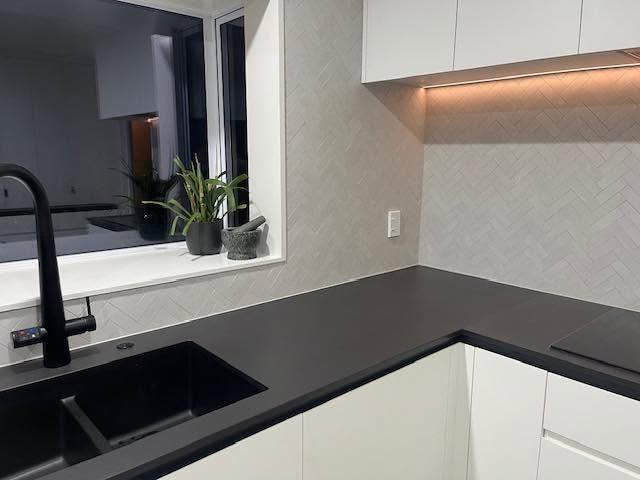 Herringbone kitchen splashback with black benchtop
