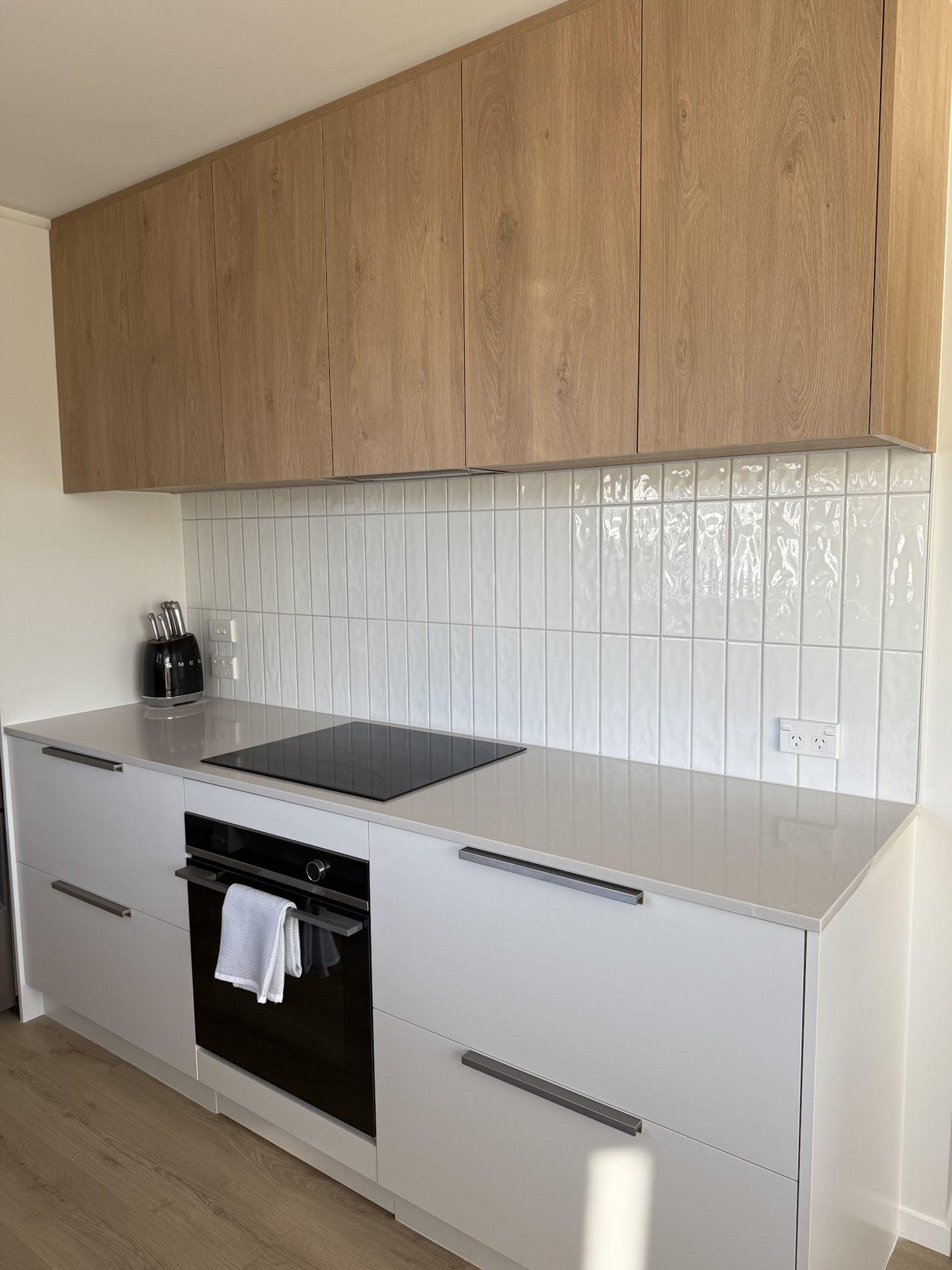 Kitchen with vertical-stack white tile splashback