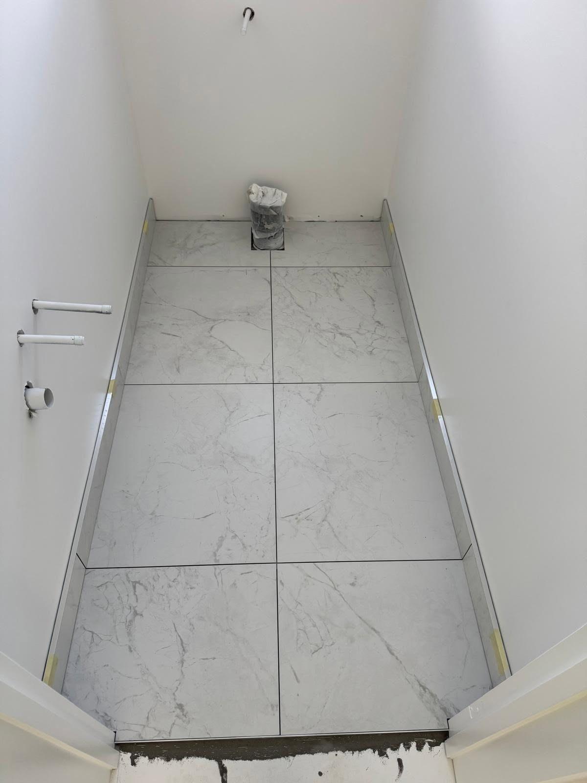 Marble-look bathroom floor tiles, freshly laid