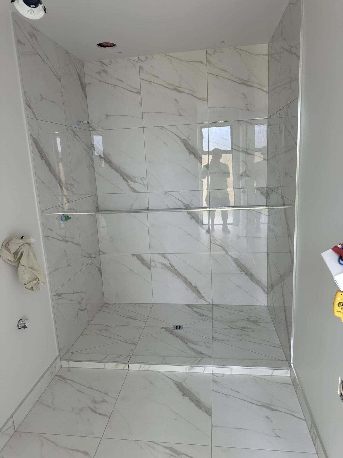 Marble-look shower tiles with glass shelf