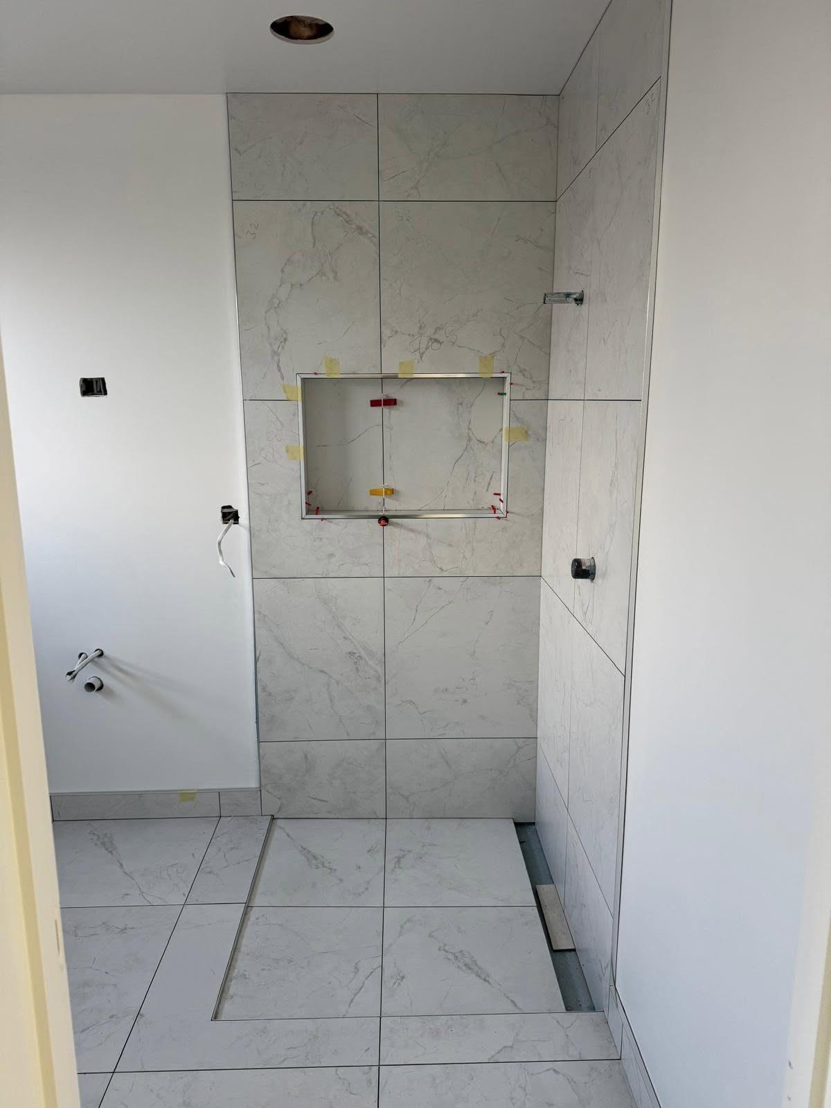 Shower niche and linear drain with marble-look tiles