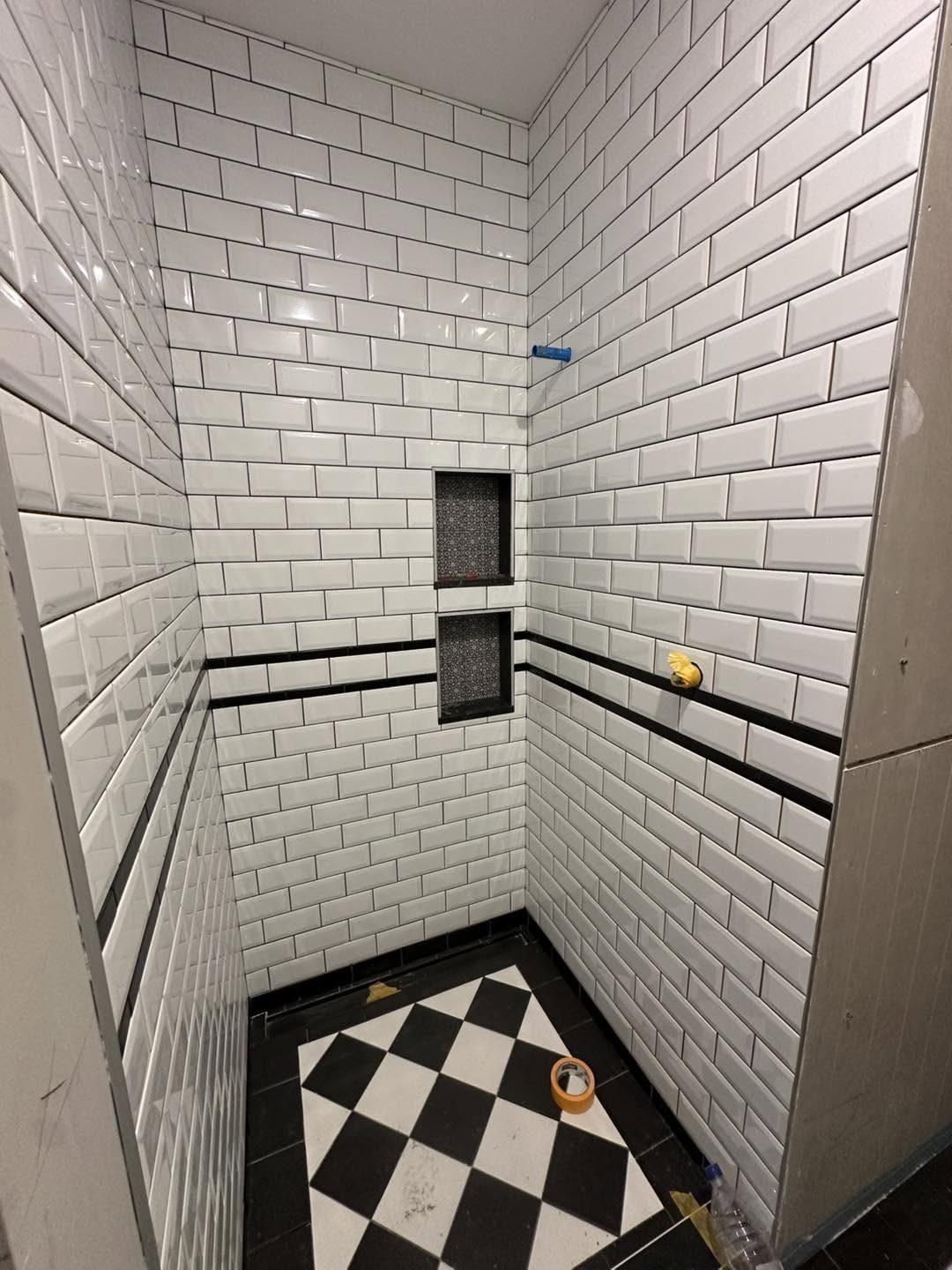 Subway tile shower with black and white checkerboard floor