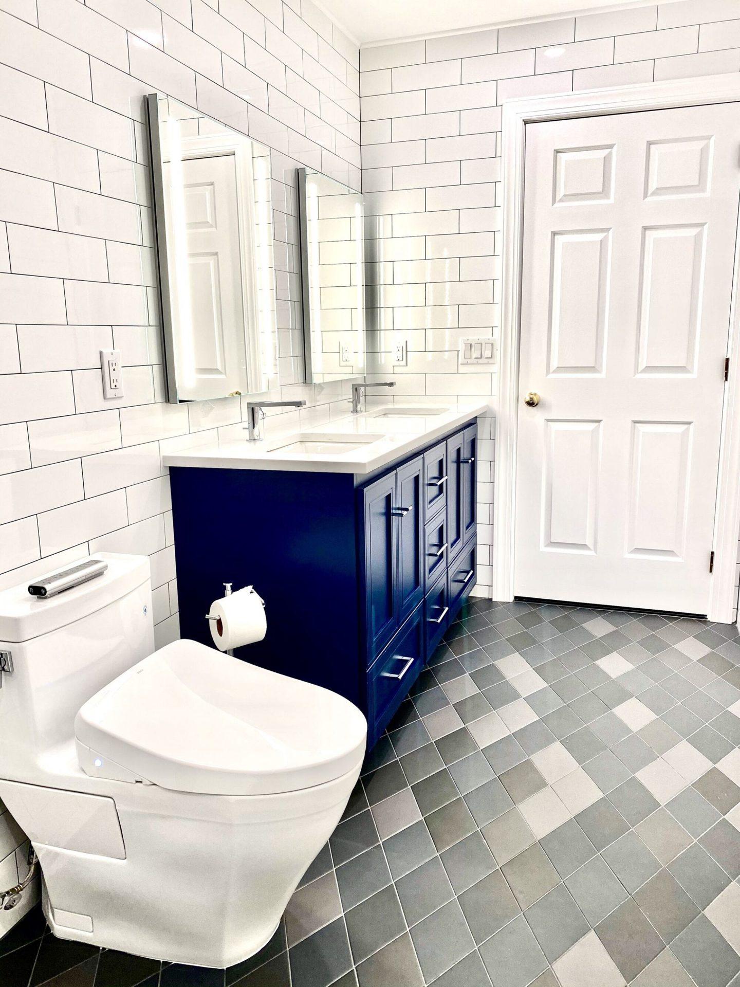 Subway wall tiles and patterned floor in a bathroom with blue vanity