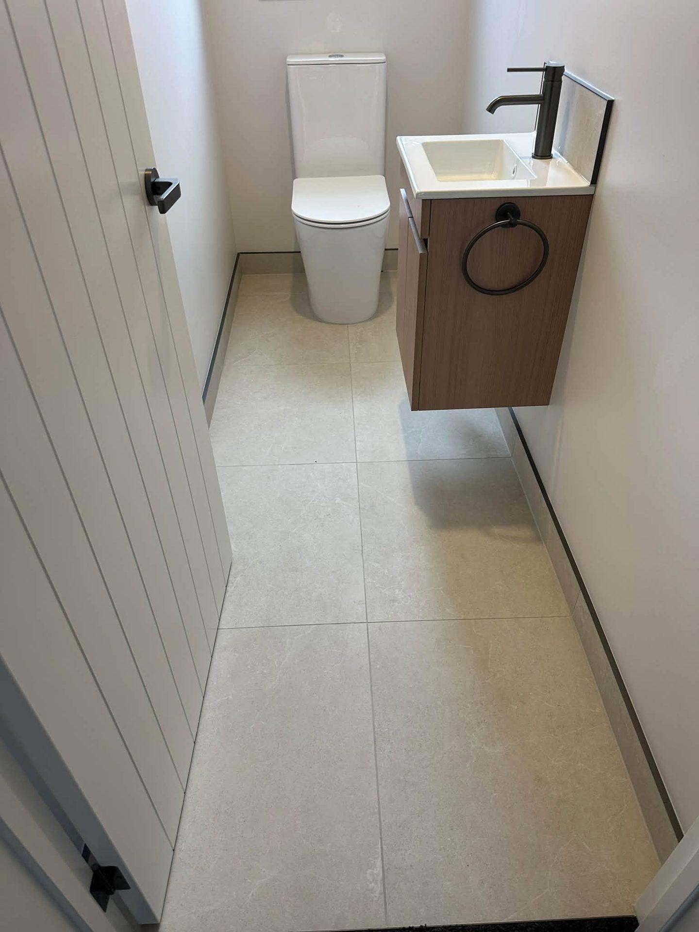 Toilet room with large-format floor tiles