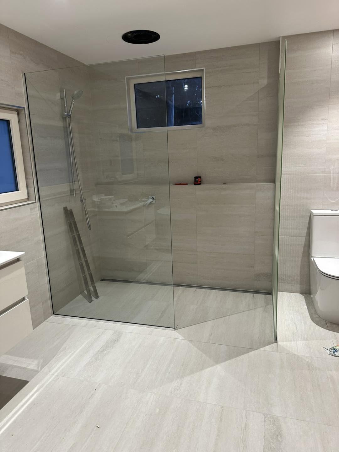Walk-in shower with glass screen and tiled ledge