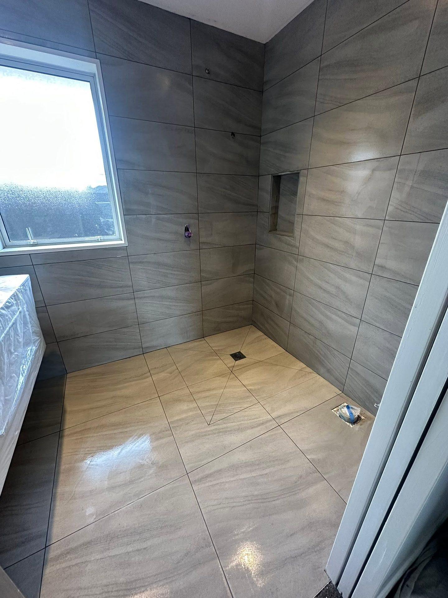 Walk-in shower with window and tiled niche