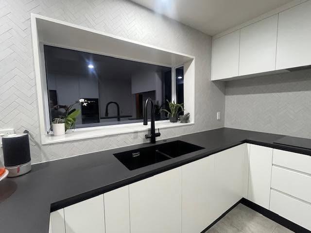 Herringbone tile splashback around a kitchen window