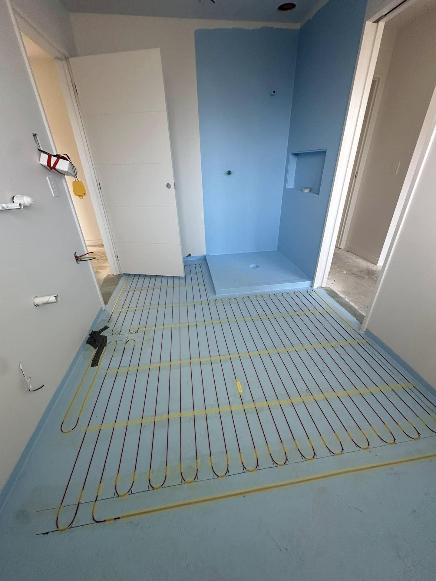 Underfloor heating mat laid over waterproofing membrane before tiling