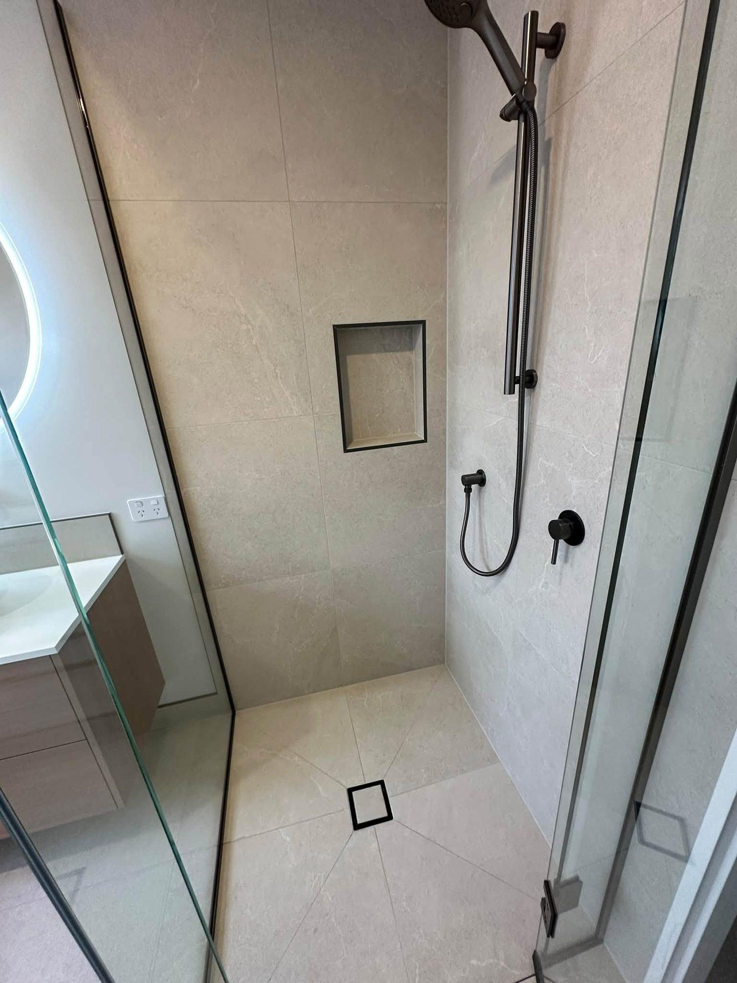 Walk-in shower with tiled niche and linear floor drain